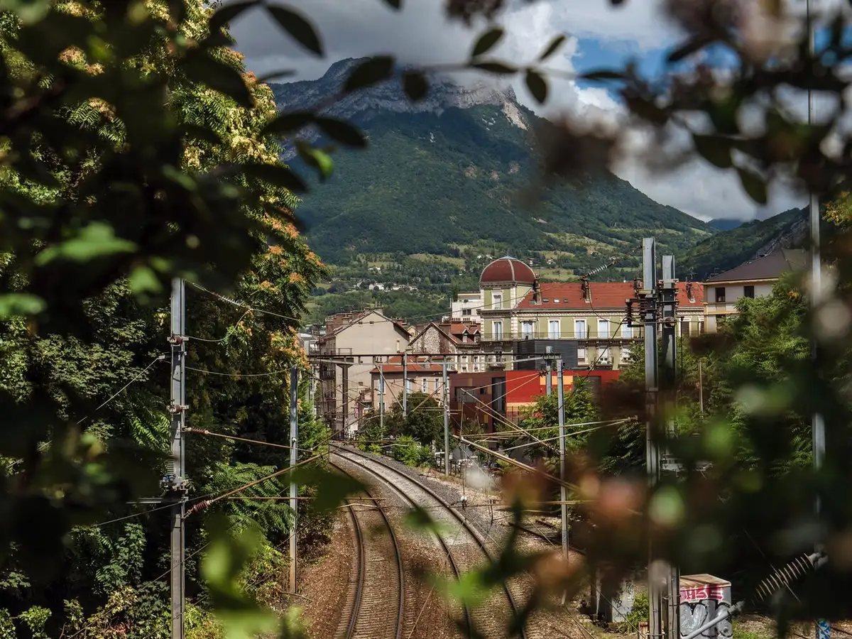 Immeubles de Grenoble et voie ferrée au pied des falaises calcaires du massif