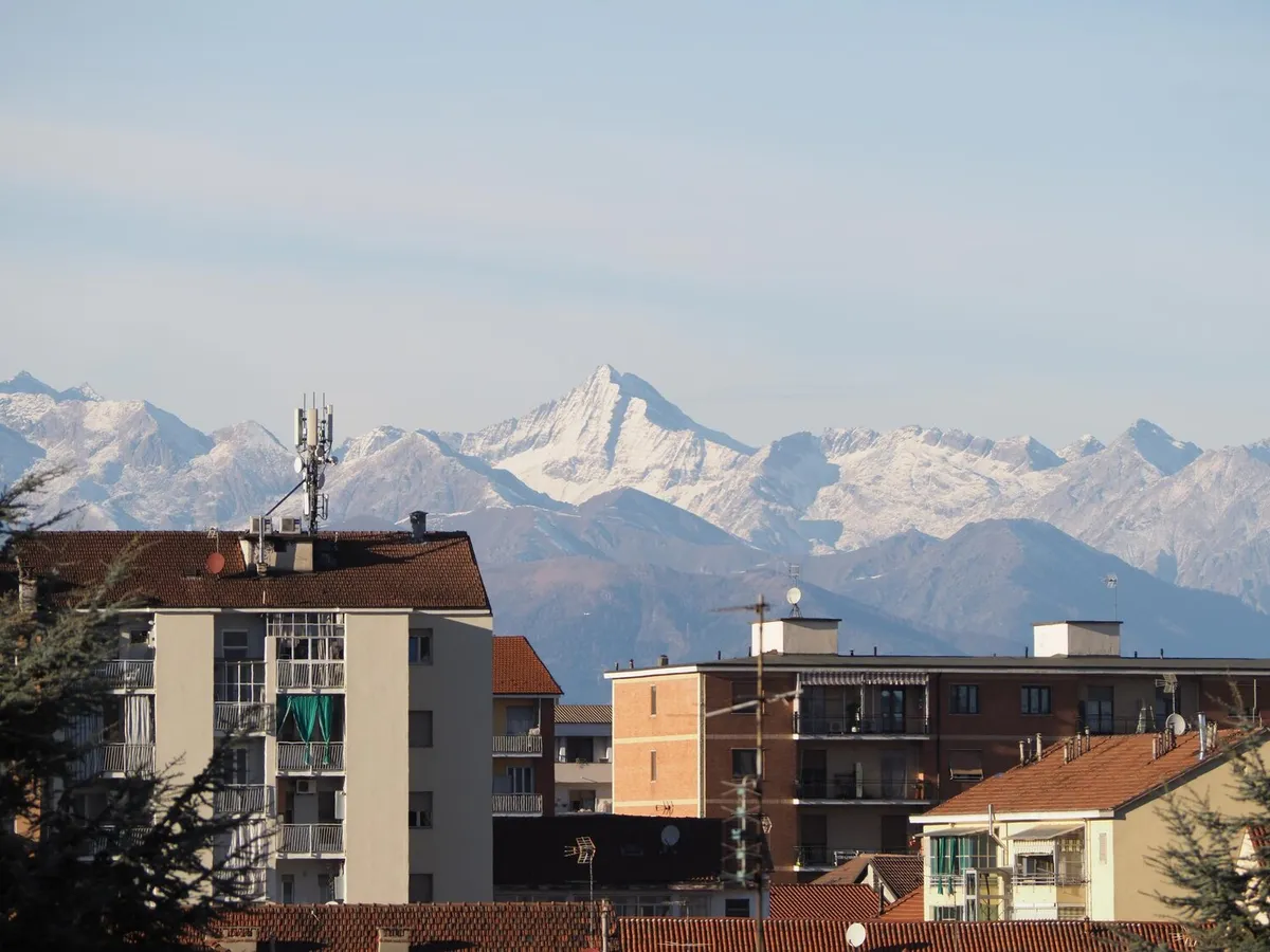 Immeubles collectifs des années 1960 et 1970 devant une chaîne de montagnes enneigées